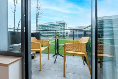 a patio with chairs and a table on a balcony at Eva R Apartments in Druskininkai
