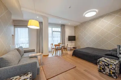 a bedroom with a bed and a couch and a table at Eva R Apartments in Druskininkai