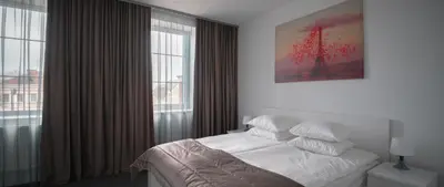 a bedroom with a bed and a large window at Laurentroom Oldtown in Ukmergė