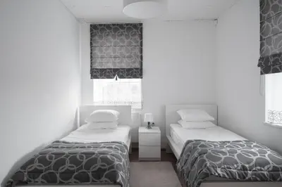a bedroom with two beds and a window at Laurentroom Oldtown in Ukmergė