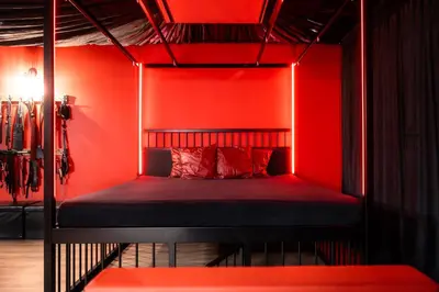 a bedroom with a bed with red walls at BDSM Red Apartments in Vilnius