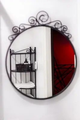 a mirror with a reflection of a chair in it at BDSM Red Apartments in Vilnius