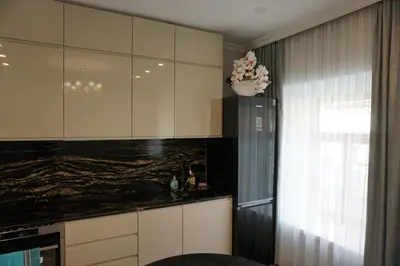 a kitchen with white cabinets and a black counter top at Heart of Vilnius Apartment in Vilnius