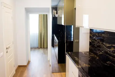 a kitchen with white cabinets and a black counter top at Heart of Vilnius Apartment in Vilnius