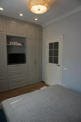 a bedroom with a bed and a television and a chandelier at Heart of Vilnius Apartment in Vilnius