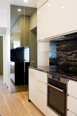 a kitchen with white cabinets and a black refrigerator at Heart of Vilnius Apartment in Vilnius