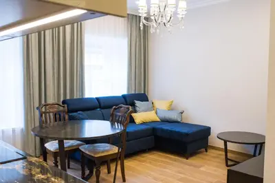 a living room with a blue couch and a table at Heart of Vilnius Apartment in Vilnius