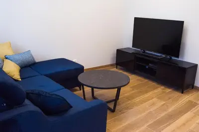 a living room with a blue couch and a tv at Heart of Vilnius Apartment in Vilnius