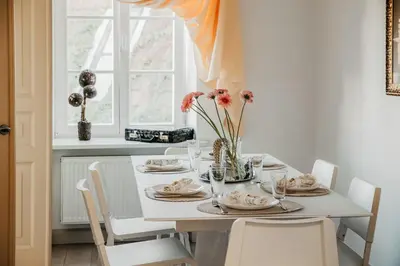 a white dining room table with a vase of flowers at Spacious - 140 square meters Apartment, Vilnius City Centre in Vilnius