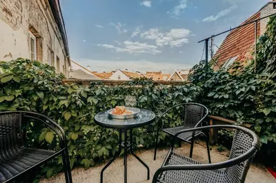 a table with chairs and a bowl of food on a balcony at Spacious - 140 square meters Apartment, Vilnius City Centre in Vilnius