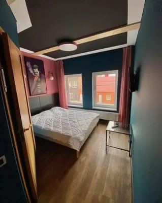 a small bedroom with a bed and two windows at Apartments in Kaunas in Kaunas