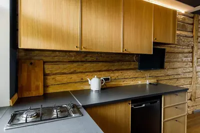 a kitchen with wooden cabinets and a sink and a stove at Apartments in Kaunas in Kaunas