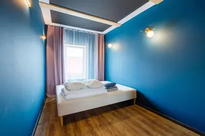 a bed in a blue room with a window at Apartments in Kaunas in Kaunas