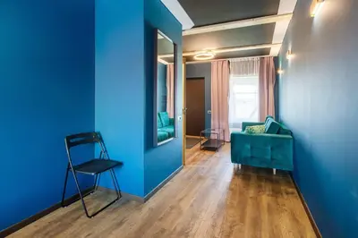 a blue room with a green couch and a mirror at Apartments in Kaunas in Kaunas