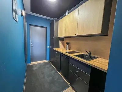 a small kitchen with a sink and a blue wall at Apartments in Kaunas in Kaunas