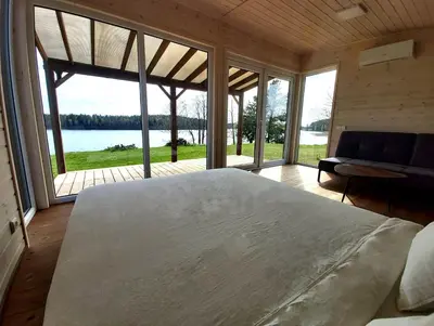 a bedroom with a large bed and a large window at Siesarties Namukas in Mindūnai