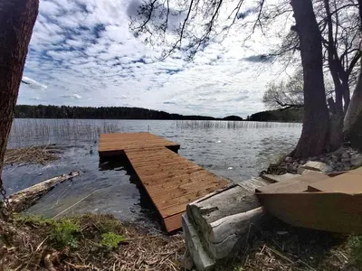 a wooden dock in the middle of a lake at Siesarties Namukas in Mindūnai