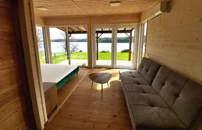 a room with a couch and a bed and windows at Siesarties Namukas in Mindūnai