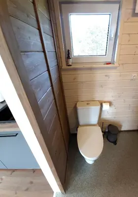 a small bathroom with a toilet and a window at Siesarties Namukas in Mindūnai