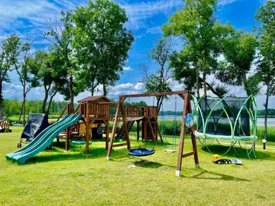 a park with a playground with slides and swings at Vastapo Vilos in Kaniūkai