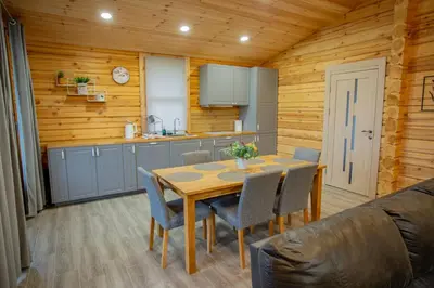 a kitchen and dining room with a table and chairs at Vastapo Vilos in Kaniūkai