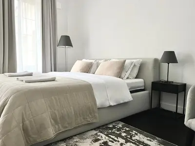 a white bedroom with a large bed and a window at Vilnius Apartments & Suites – Old Town in Vilnius