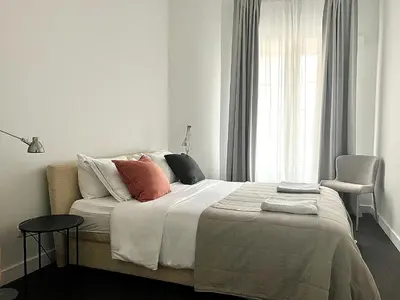 a bedroom with a bed with pillows and a window at Vilnius Apartments & Suites – Old Town in Vilnius