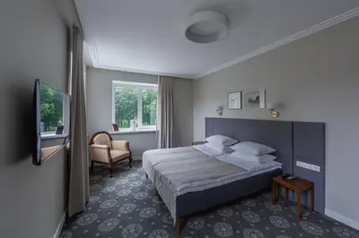 a hotel room with a bed and a chair at Park Hotel Šiauliai SPA & Conference in Šiauliai