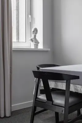 a black and white photo of a chair next to a window at Park Hotel Šiauliai SPA & Conference in Šiauliai