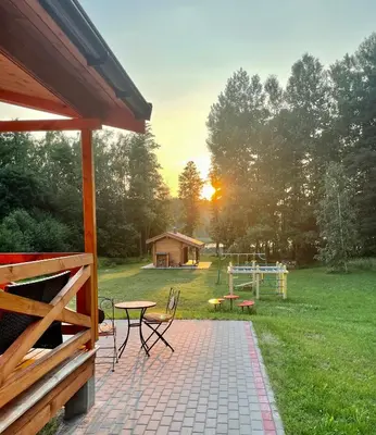 a patio with a table and chairs and a playground at Zarasaičio ežero sodyba in Magučiai