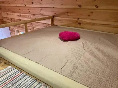 a pink pillow sitting on top of a bed at Zarasaičio ežero sodyba in Magučiai