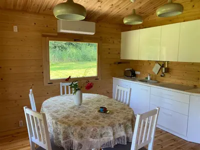 a kitchen with a table and chairs and a kitchen with a window at Zarasaičio ežero sodyba in Magučiai