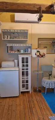 a small kitchen with a refrigerator and a table at PO NENDRIŲ STOGU in Šiauliai