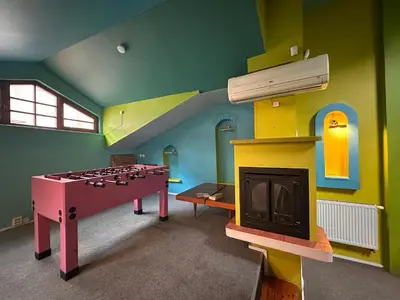 a room with a play room with a table and a fireplace at 25 Hours Hostel in Vilnius