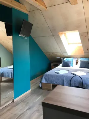 a bedroom with two beds and a blue wall at Daukanto apartamentai in Anykščiai