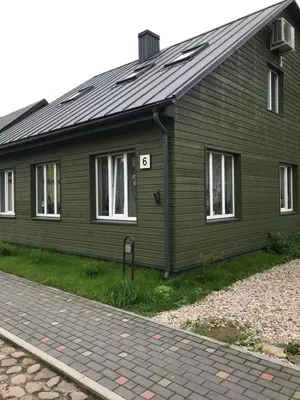 a green house with the number six on it at Daukanto apartamentai in Anykščiai