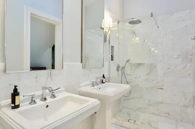 a white bathroom with a sink and a mirror at Vilnius Apartments & Suites - Town Hall in Vilnius