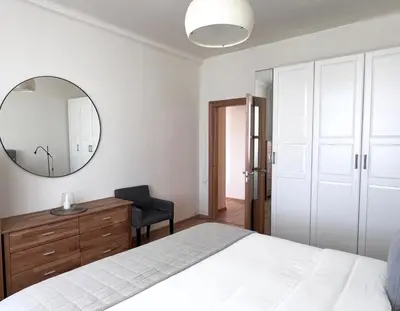 a bedroom with a white bed and a mirror at Vilnius Apartments & Suites - Town Hall in Vilnius