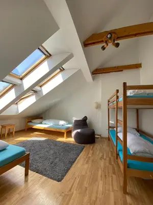 a attic room with two bunk beds and a rug at Jimmy Jumps House in Vilnius