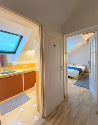 a room with a bed and a bathroom with a window at Jimmy Jumps House in Vilnius
