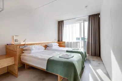a hotel room with two beds and a window at Tech Spa Coliving&Coworking Spaces in Druskininkai