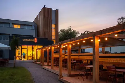 a restaurant with tables and lights in front of a building at Tech Spa Coliving&Coworking Spaces in Druskininkai