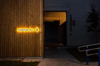 a sign that says come in on the side of a building at Tech Spa Coliving&Coworking Spaces in Druskininkai