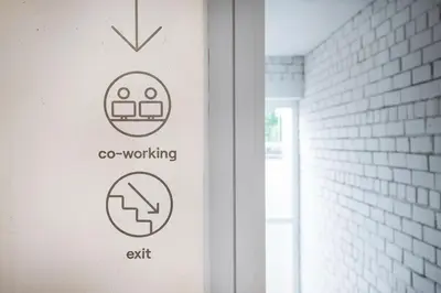 a sign on the side of a door with a sign for go working at Tech Spa Coliving&Coworking Spaces in Druskininkai