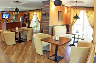 a restaurant with two tables and chairs and a bar at Vila Kelmyne in Molėtai