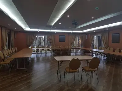 a conference room with tables and chairs and windows at Vila Kelmyne in Molėtai