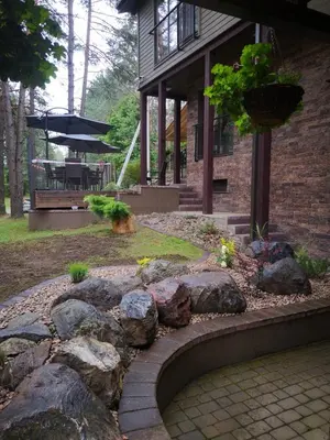 a house with a rock garden in front of it at Vila Kelmyne in Molėtai