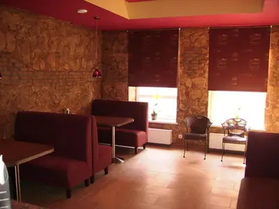 a dining room with tables and chairs and windows at Guest house 
