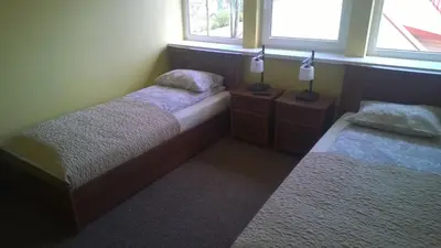 two beds in a room with two windows at Guest house 