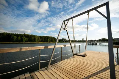 a dock with a swing on the side of a lake at Guest house 